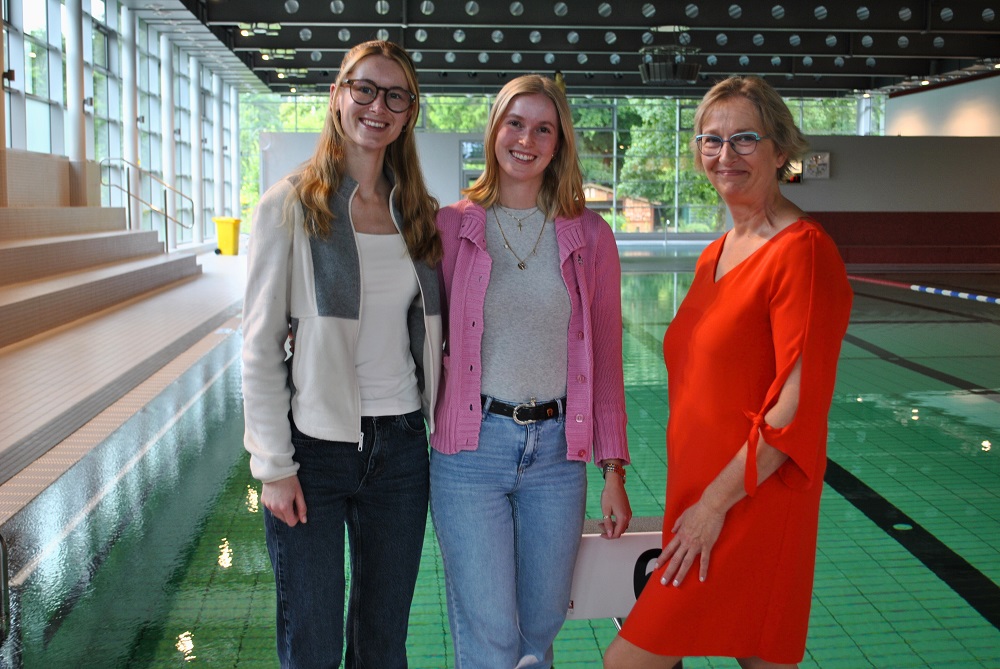 Foto: Marie-Theres Röschinger, Johanna Sophia Röschinger und Sabine Lillmanntöns vor dem Schwimmbecken