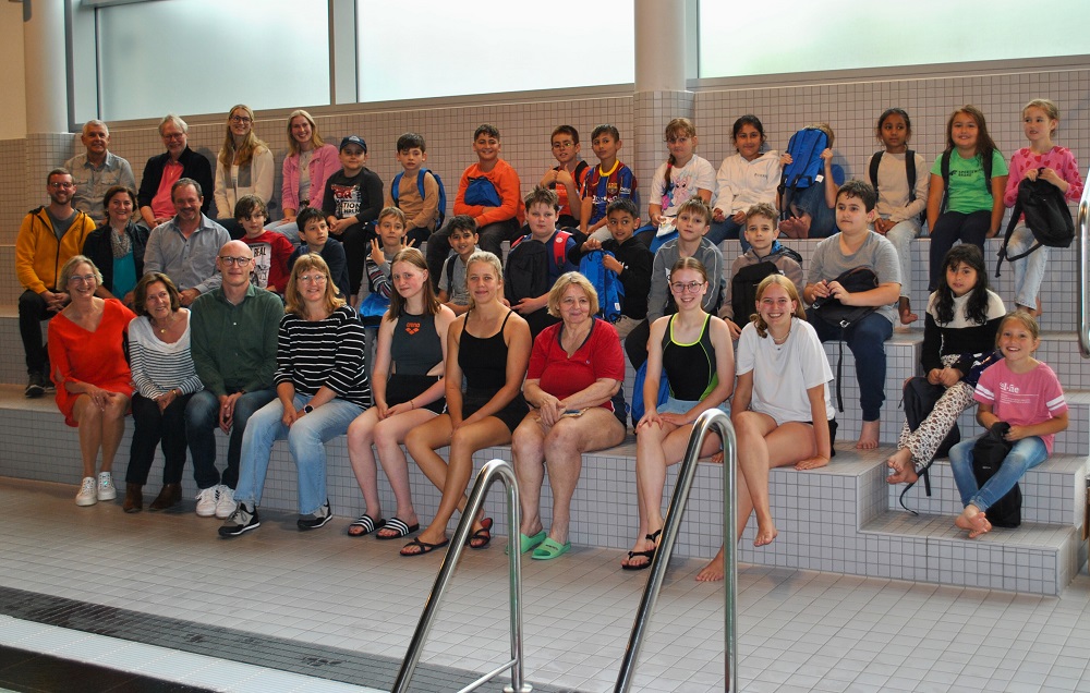 Foto: Gruppe auf Sitzbänken in der Schwimmhalle