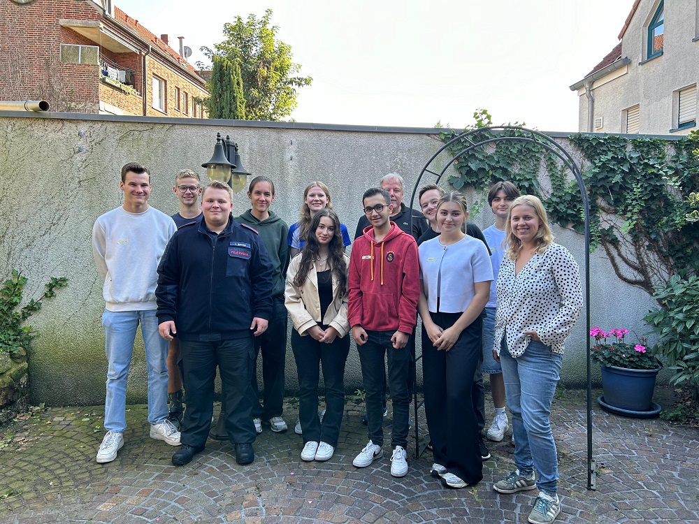 Foto: Gruppe junger Menschen vor einer Mauer