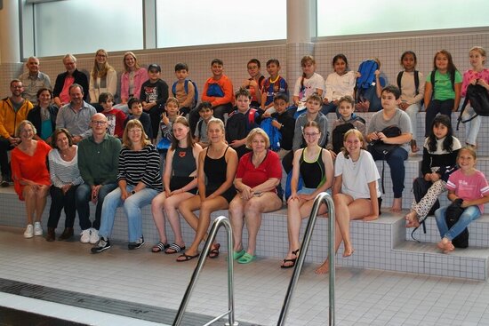 Foto: Gruppe auf Sitzbänken in der Schwimmhalle