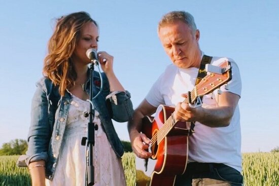 Foto: Paar mit Gitarre auf einer Wiese