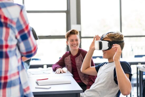 Foto: Junger Mann mit VR-Brille an einem Schreibtisch