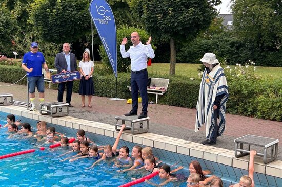 Bürgermeister Matthias Harman gab den Startschuss und feuerte die Schülerinnen und Schüler auf ihren Bahnen durchs Freibad an.