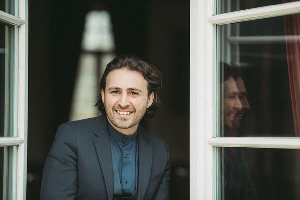 Foto: Musa Deli blickt aus dem geöffneten Fenster